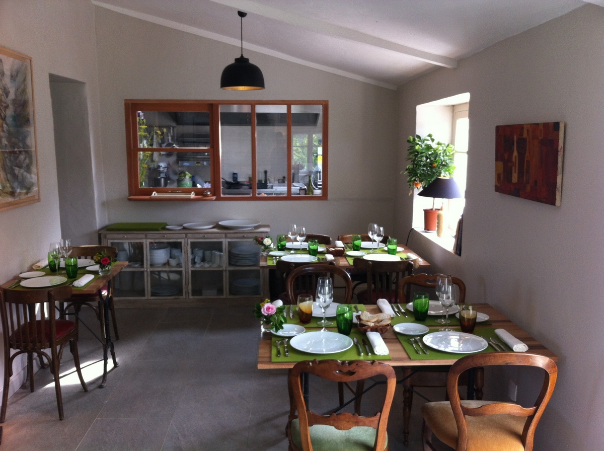 Verrière bois laqué séparant cuisine et salle de restaurant