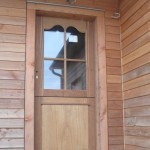 porte d'entrée fermière avec tapées de pose en ossature bois. traverse chantournée